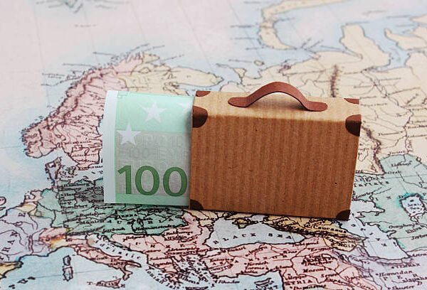 Europe city trip travel budget concept with 100 euro note and suitcase on map